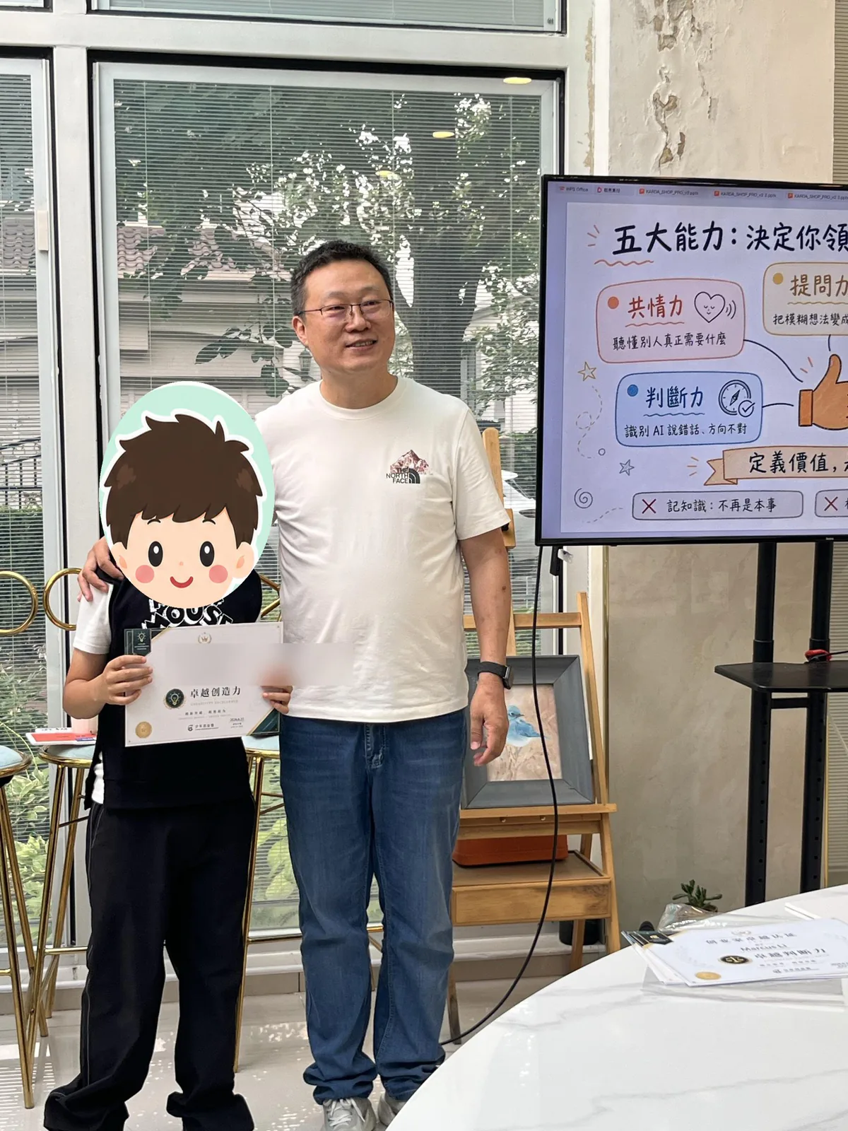 顺义首场营中孩子举起卓越创造力证书，老师在旁祝贺，孩子脸部和证书姓名已遮挡
